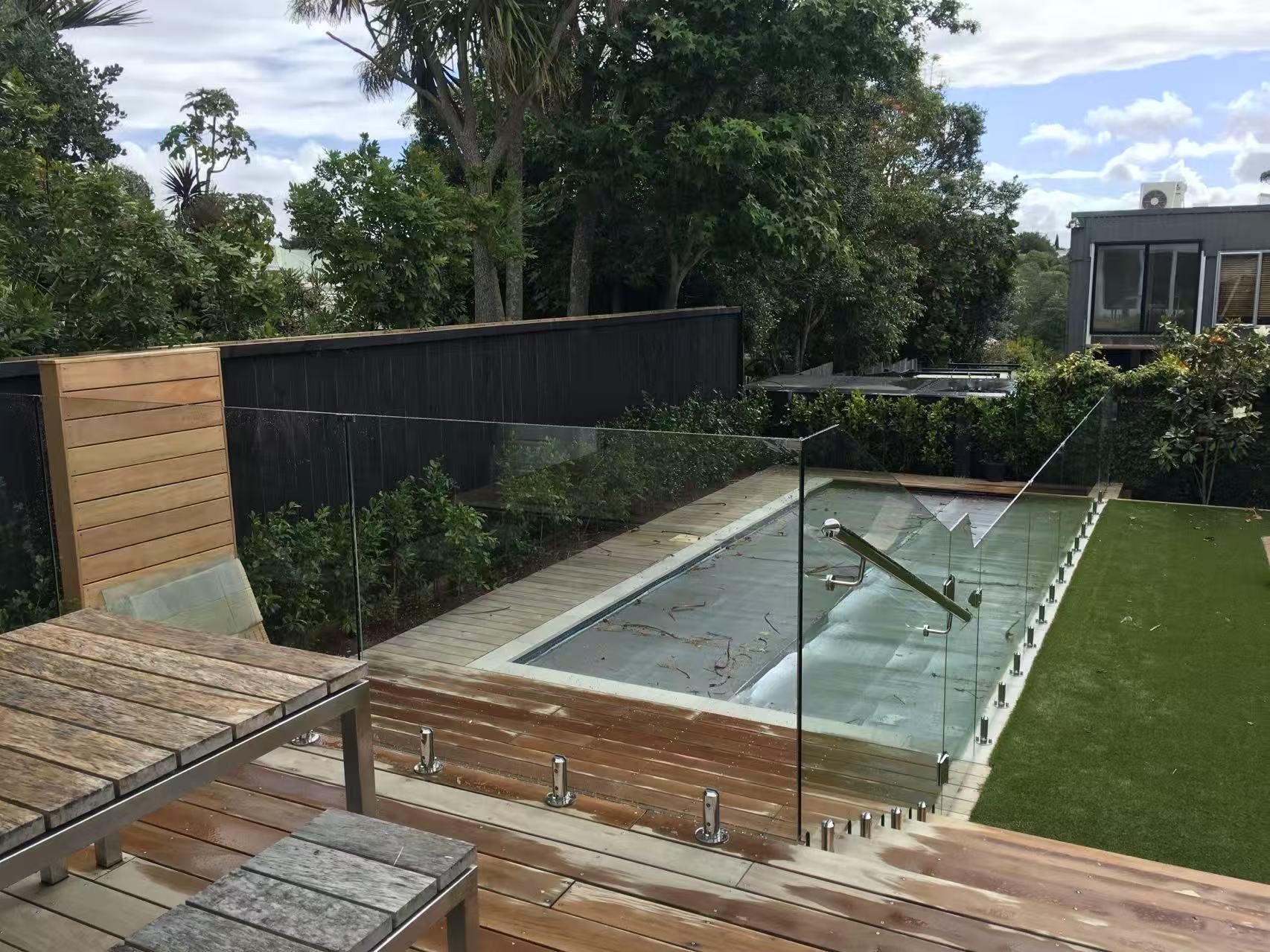 Clear glass fence and gate viewed above a residential pool