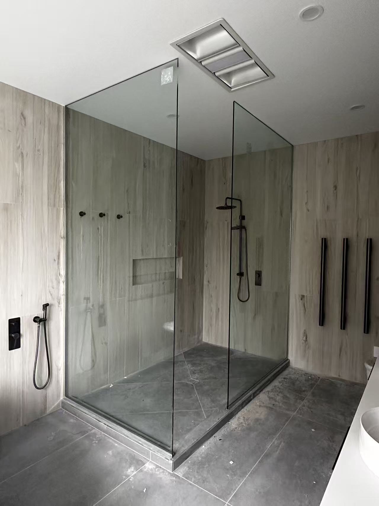Large frameless walk-in shower enclosure during installation