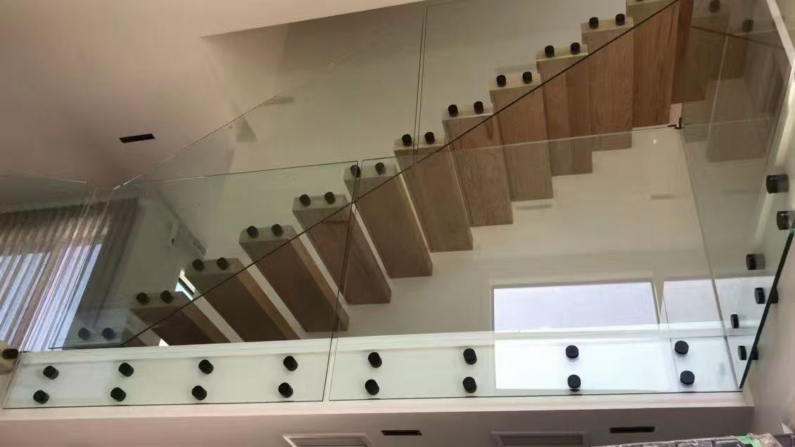 Side-fixed glass around an upper stair landing and adjoining staircase